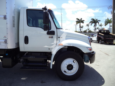 Truck cab side view showing 2021 International MV with white exterior, single front wheel, door mirror, and chassis area.