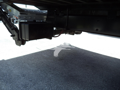 Under-truck view showing a diesel exhaust/electrical control module and frame components underneath a 2021 International MV truck.