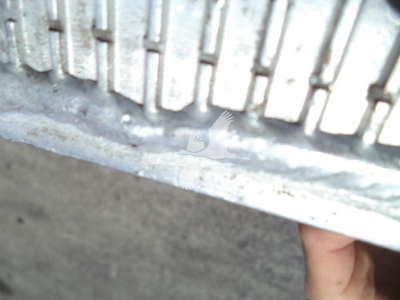 Part of a vehicle showing a metal above-tire tread with some road grime; no readable labels visible.