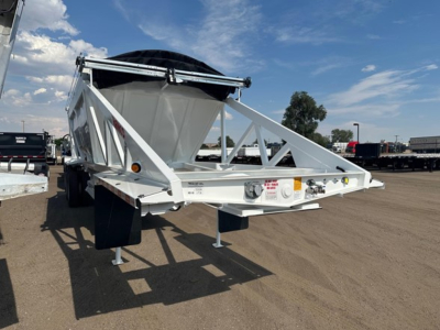Bottom dump trailer showing white steel frame with black truck bed cover and front hitch, tri-axle configuration, adjustable support stands, and stamped plates