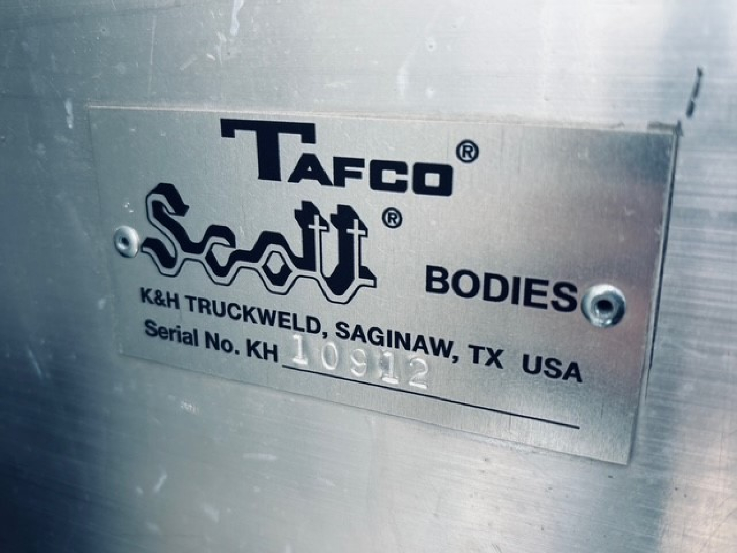 Plate showing Tafo? Tacfo? along with Sculpt? K&H Truck Werld, Saginaw, TX USA Serial No. K H 10912. BODIES. METAL plate attached to truck body.