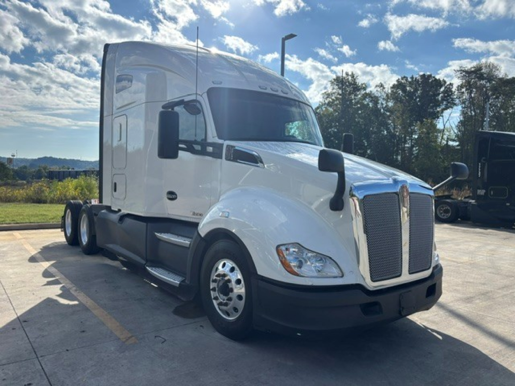 Kenworth T680 tractor-trailer cab in white showing front and left side with grille, headlights, and mirrors.