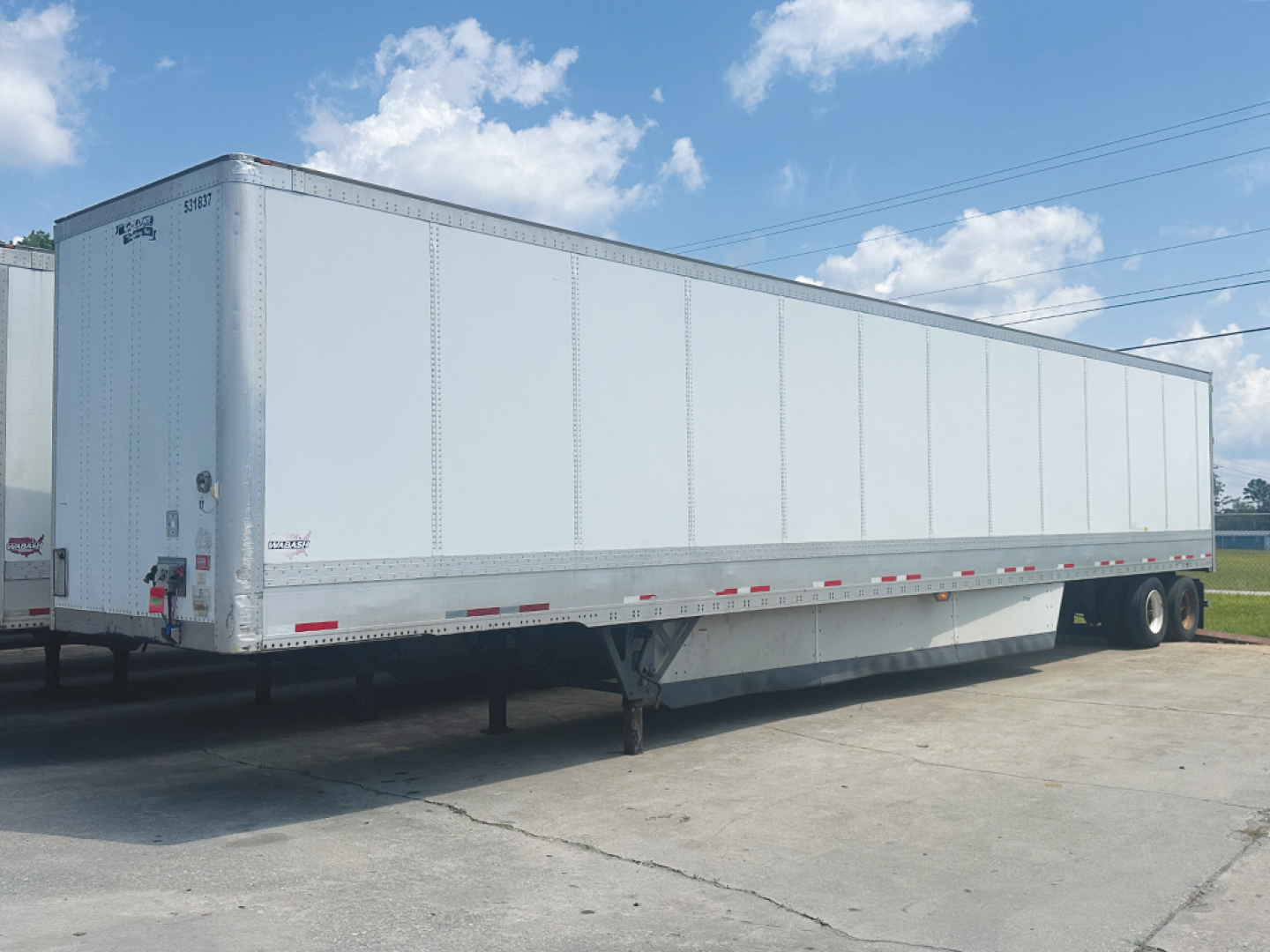 2016 Wabash DuraPlate HD Van trailer showing side walls and tandem axle configuration. Visible text includes 'WABASH' on front corner and 'DURAPLATE' branding; general exterior with reflective tape along the bottom edge.