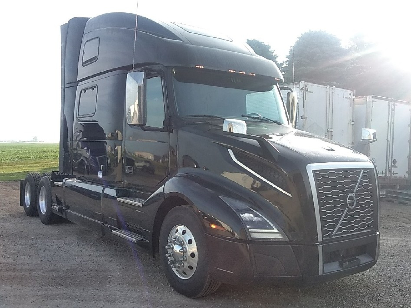 Volvo VNL64T860 sleeper cab tractor in view showing front grille, headlights, and side mirrors.