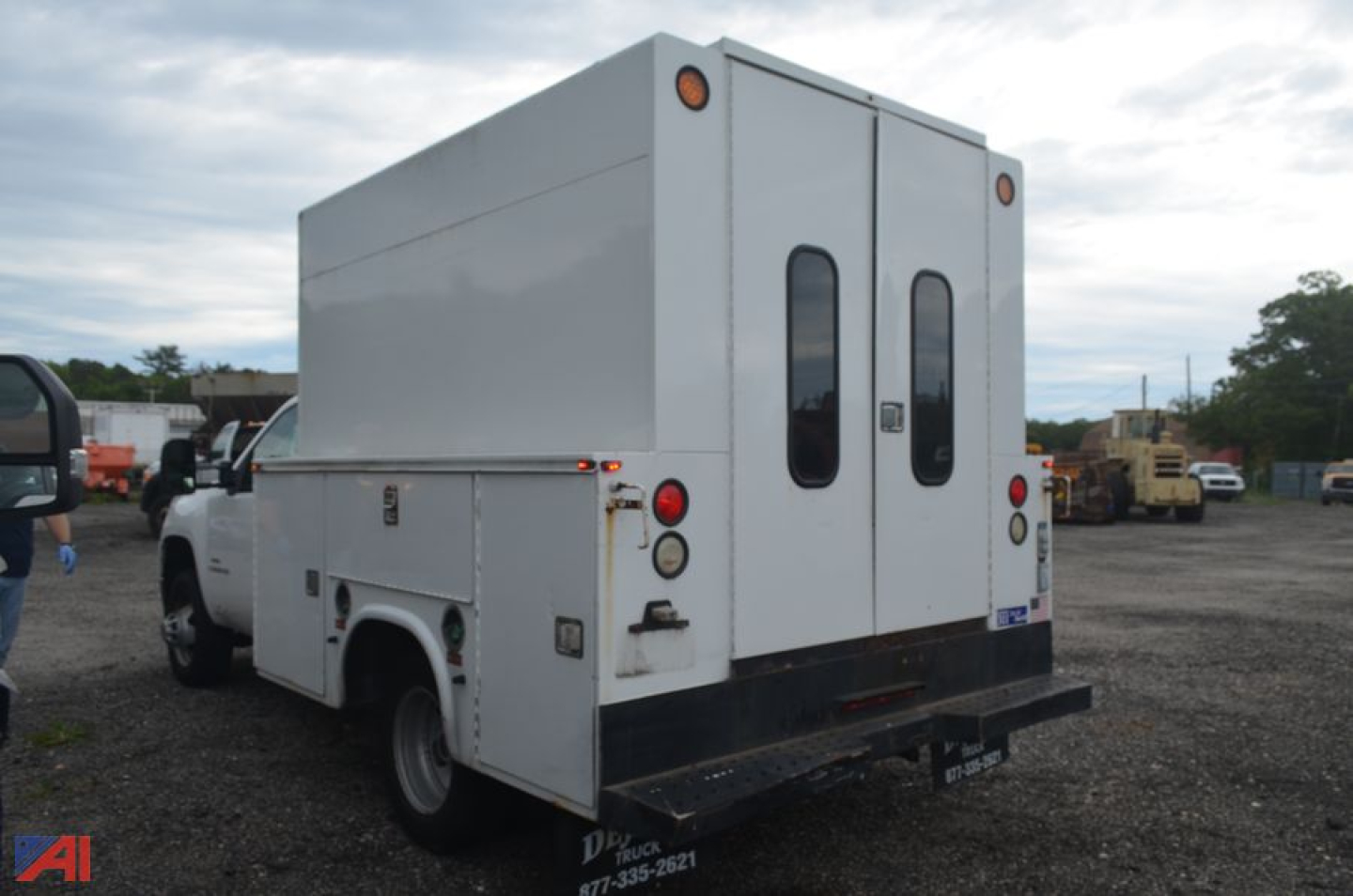 Utility service truck rear view showing dual rear doors, cargo box, and taillights; white exterior with black rear bumper.