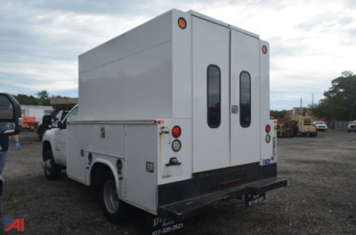 Utility service truck rear view showing dual rear doors, cargo box, and taillights; white exterior with black rear bumper.