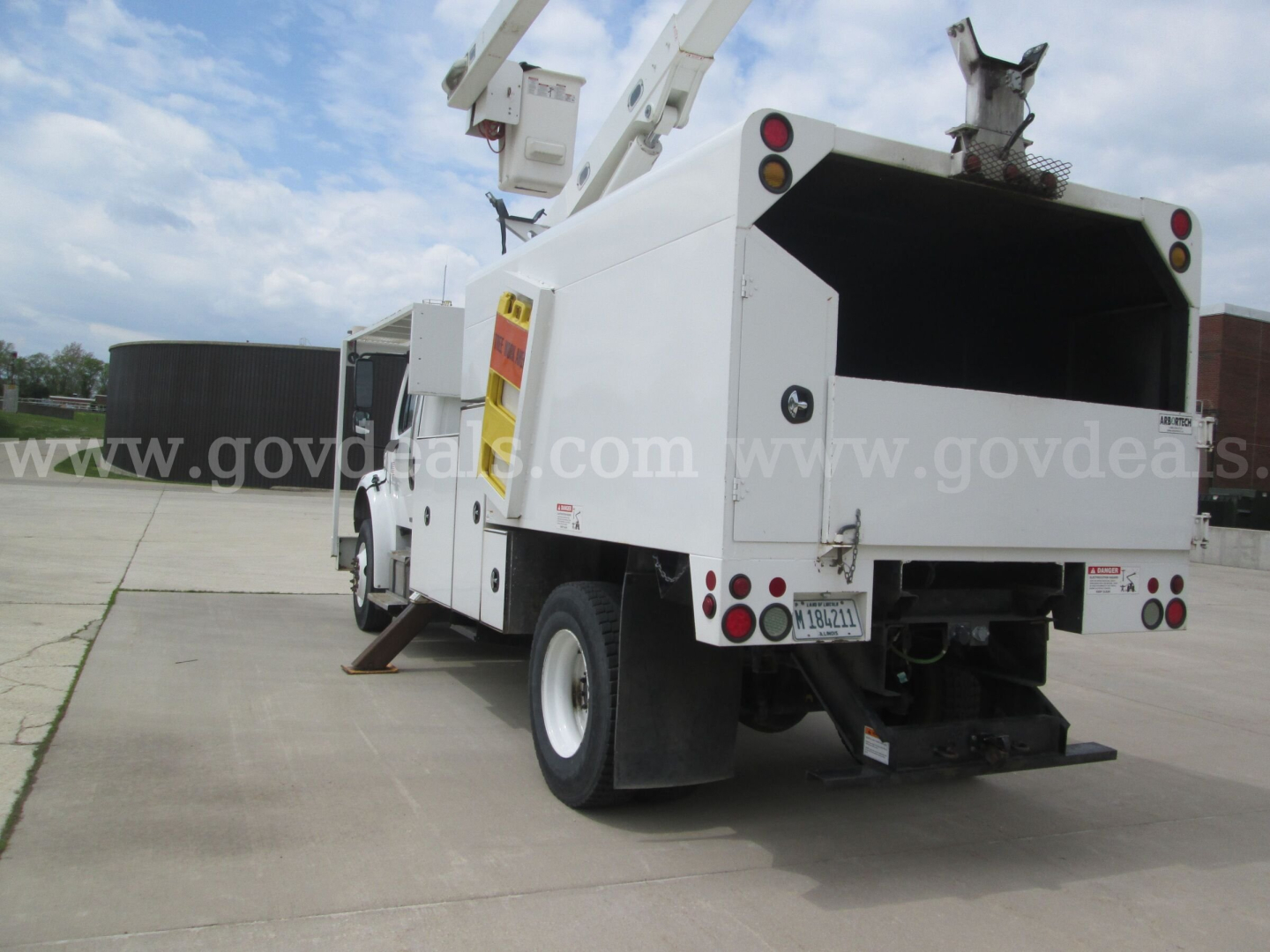 Freightliner M2 106 bucket truck rear view showing utility body and boom crane with empty bed and lights.