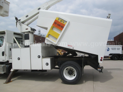 Freightliner M2 106 aerial bucket truck with bucket lift in raised position. Side-mounted white utility body with yellow warning label on access panel. Watermark across image.