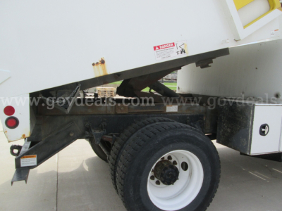 Truck rear wheel and underbody of a 2011 Freightliner M2 106 bucket truck showing wheel, frame, and underbody components.
