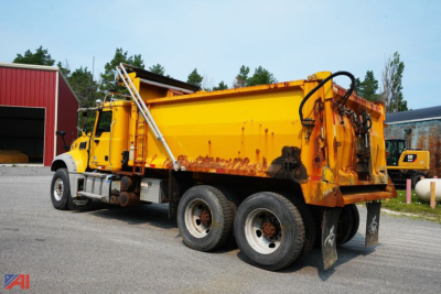 Dump truck with yellow cab and orange dump bed showing side view.