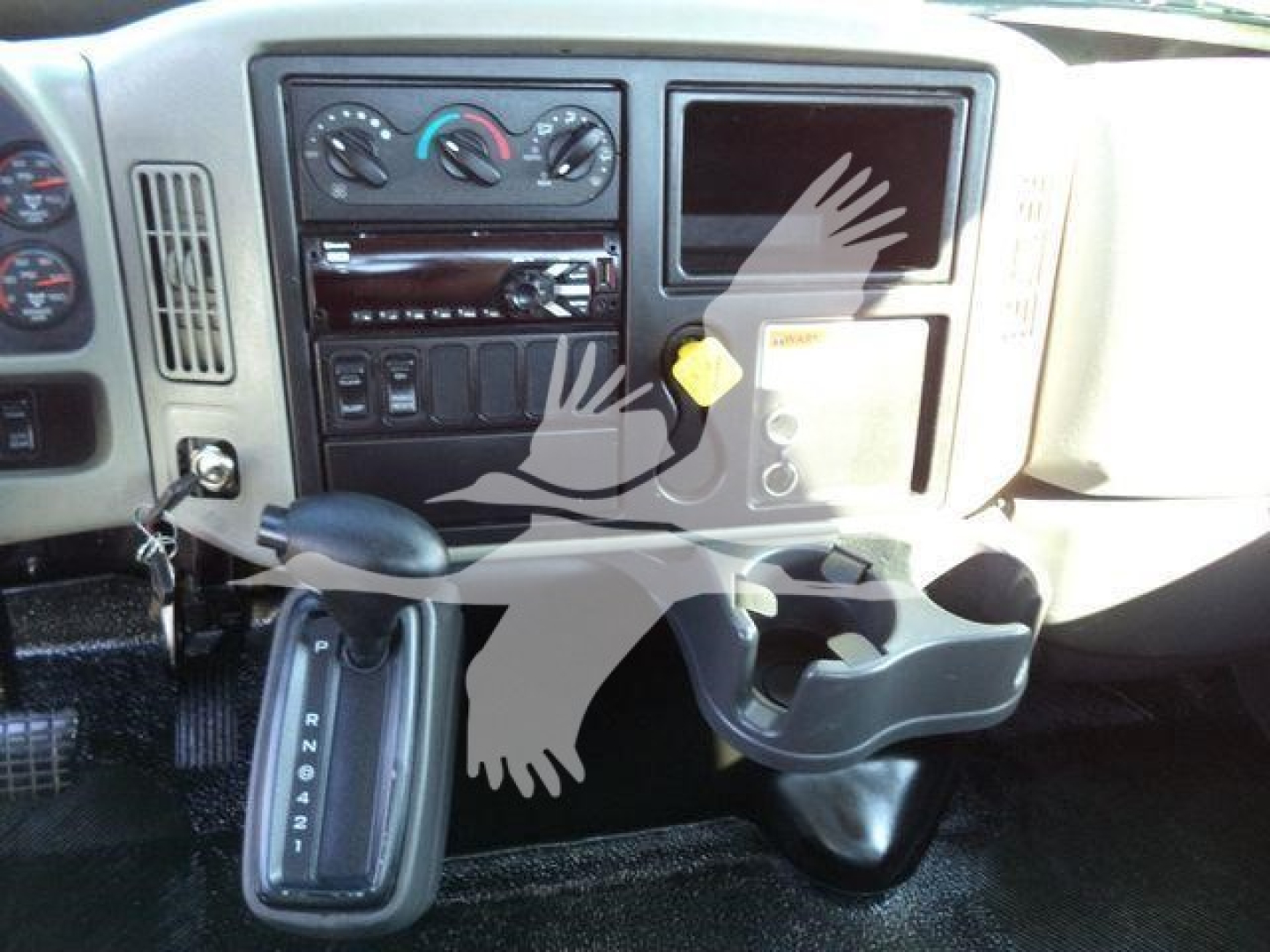 Dashboard and center console of a 2019 International 4300 showing gear shifter, climate controls, radio, and cup holder.