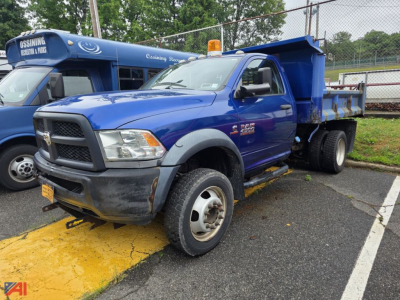 Blue Ram 4500 dump truck with a plow, facing left, in a parking lot.