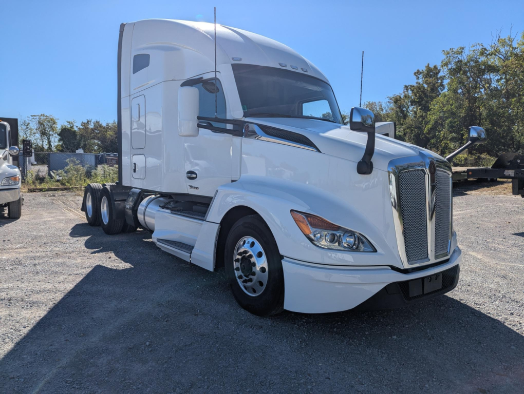 Kenworth T680 tractor-trailer cab in white, front-right view, showing aerodynamic sleeper, chrome grille, headlights, side mirrors; no visible text legible on decals.