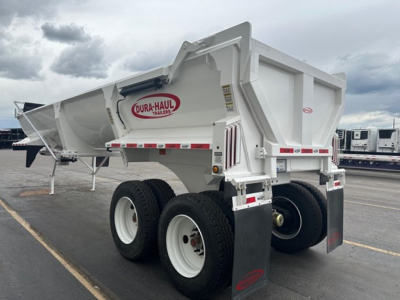 Dura-Haul frameless 1/2 round rock end dump trailer in a parking lot, white with red logo, dual rear wheels, mud flaps, side marker lights.