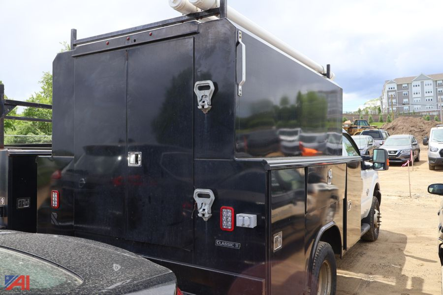 Ford F350 utility truck with large black equipment box in service bed side view showing storage compartments and rear doors.