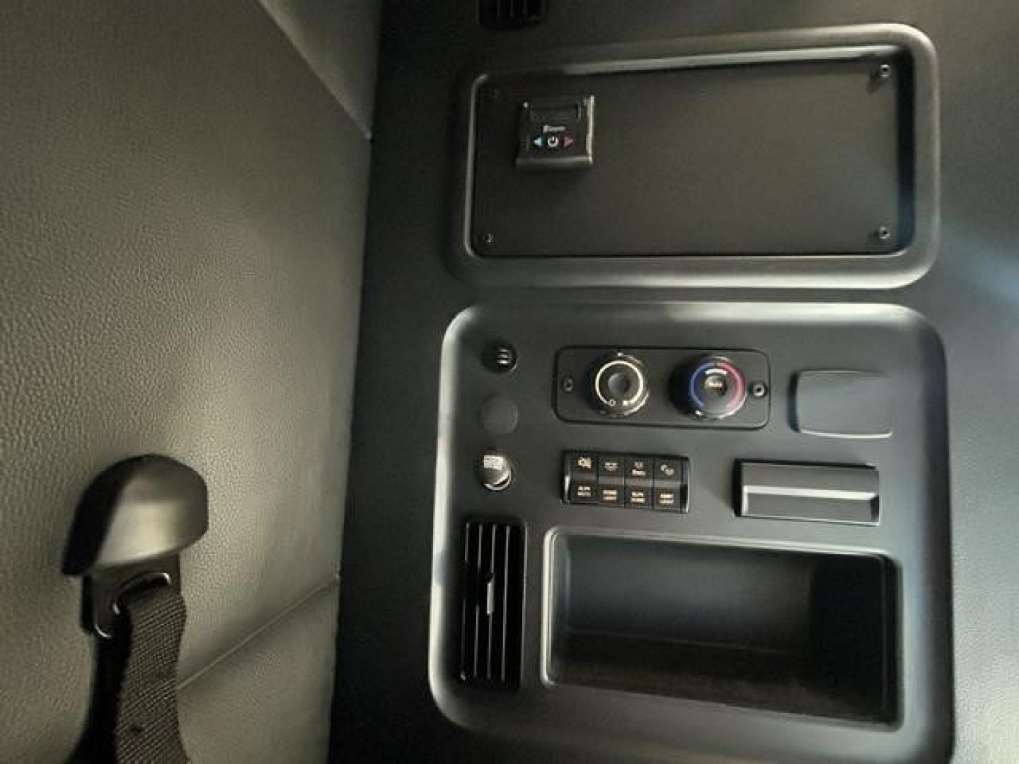 Cab interior panel showing climate controls, ashtray/platform with switches and a small vent; no legible model text visible.