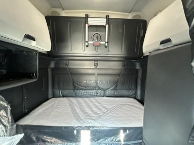 Freightliner Cascadia 126 sleeper cab interior showing bunk bed area and storage cabinets.