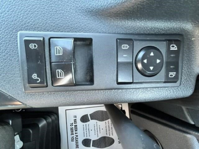 Truck cab door panel with window/lock controls and mirror adjustment joystick visible.