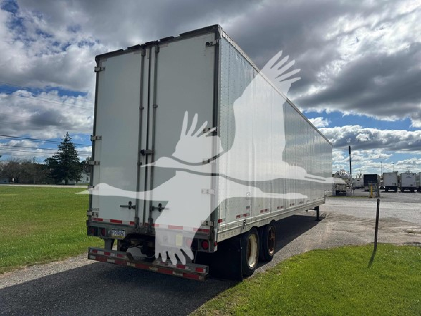 Manac drop trailer seen from rear-left side showing twin rear doors and dual rear axle