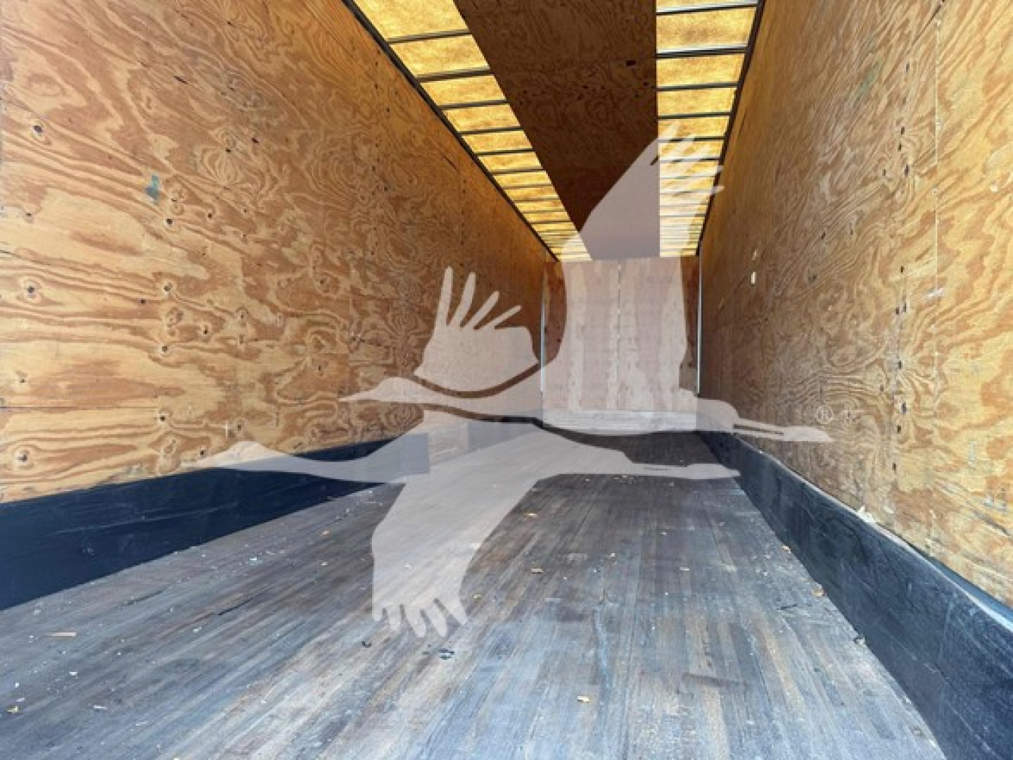 Trailer interior showing wooden walls and metal floor of a 2015 Manac drop van cargo area