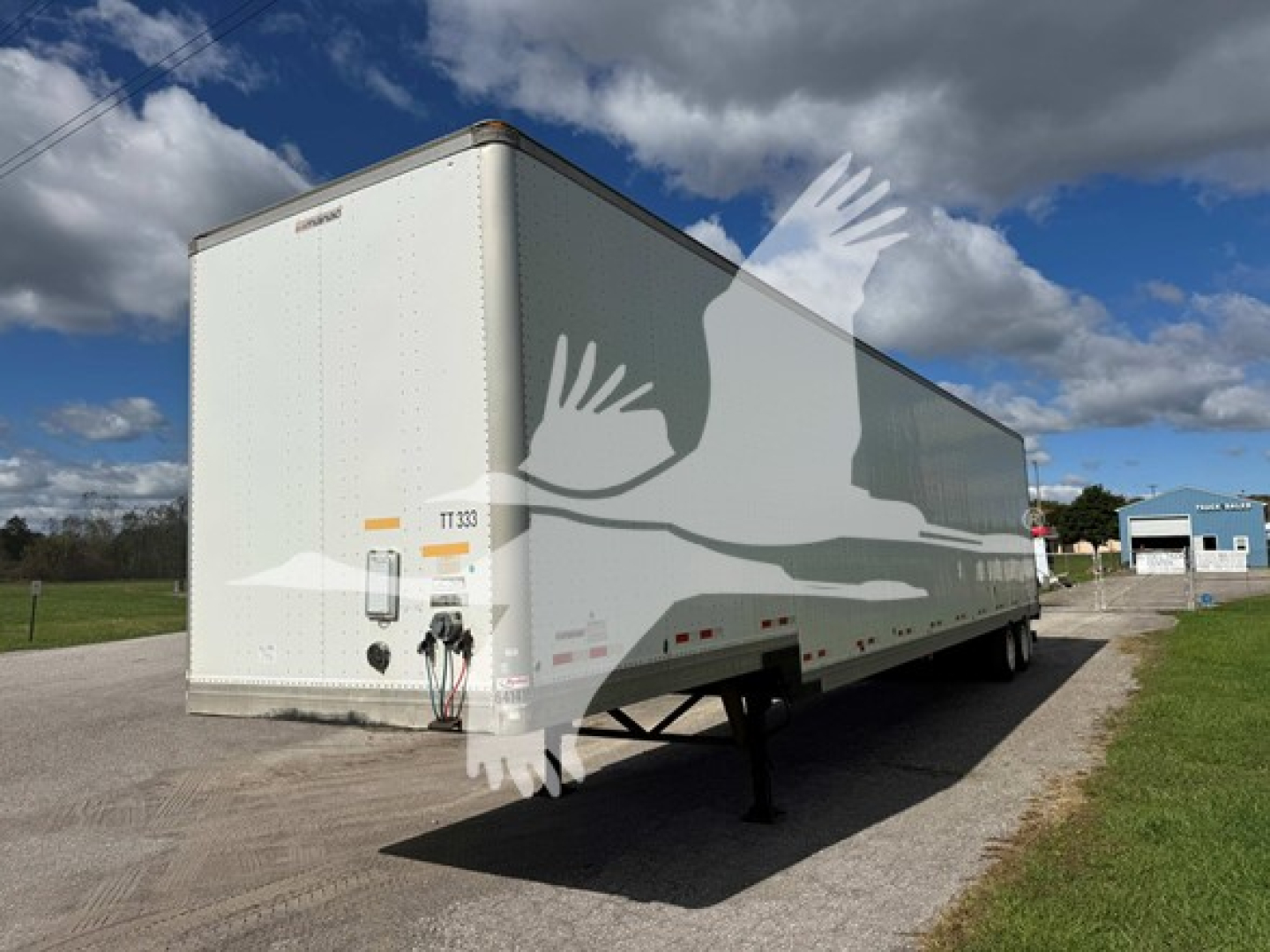 2015 Manac drop van trailer in a lot, white exterior, rear and left side visible with landing gear and hitch area.