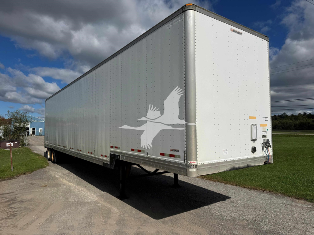 Manac drop van trailer with white cargo box and a flying bird graphic on the side, viewed from rear-left angle.