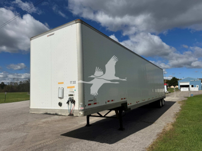 2015 Manac Drop Van trailer side view showing logo and front access with landing legs and hitch area.