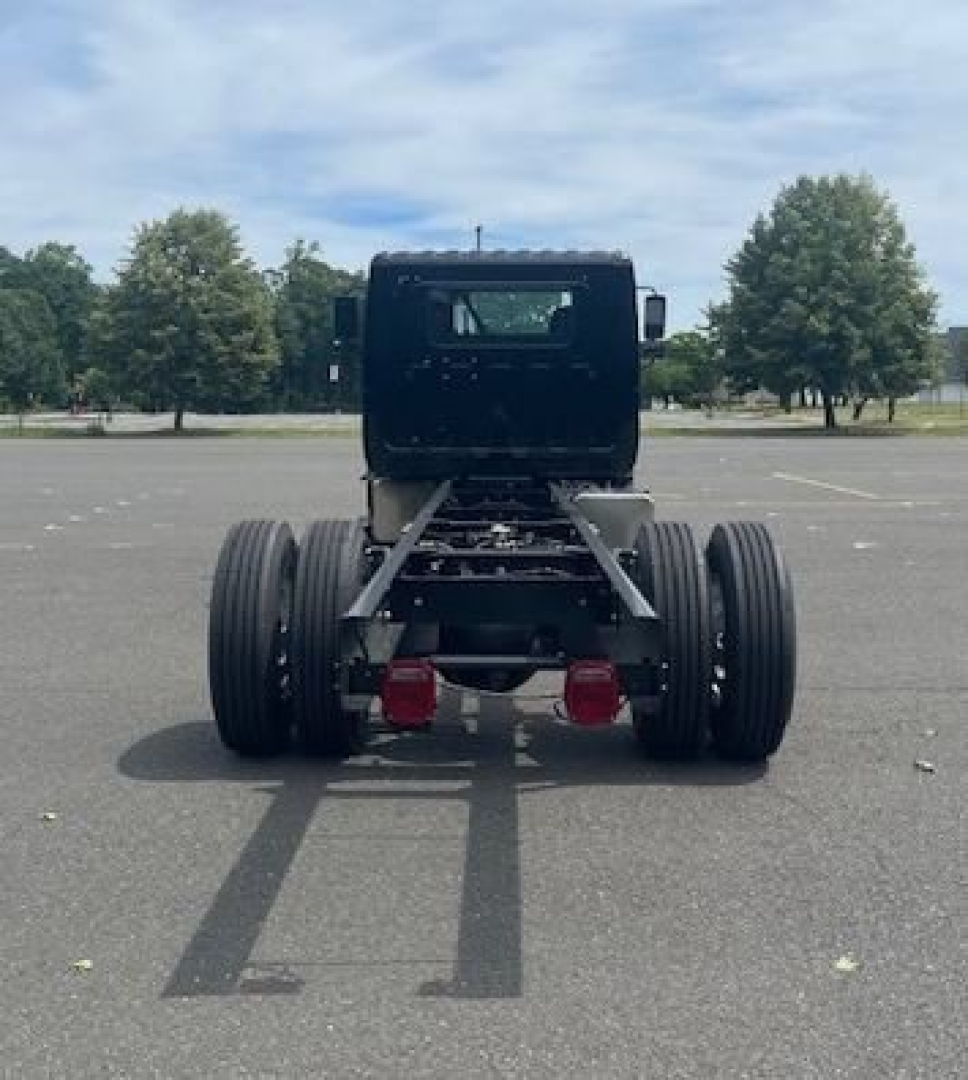 Rear view of a cab chassis truck showing dual rear axles and chassis frame; no engine or cab details visible.