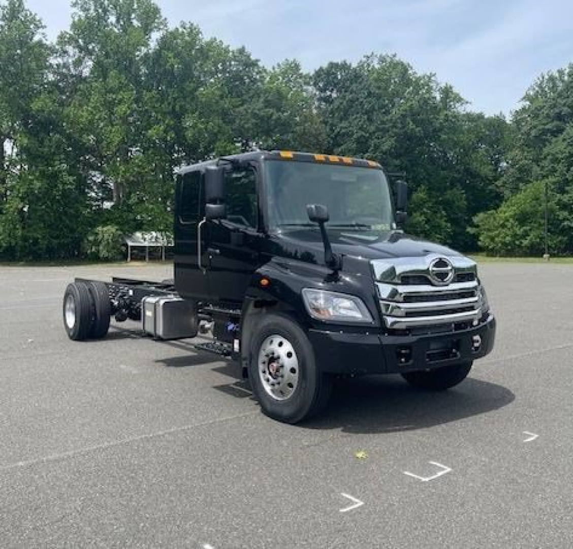 2027 Hino L7 cab chassis truck in view showing front and side profile with dual rear wheels and fuel tanks.