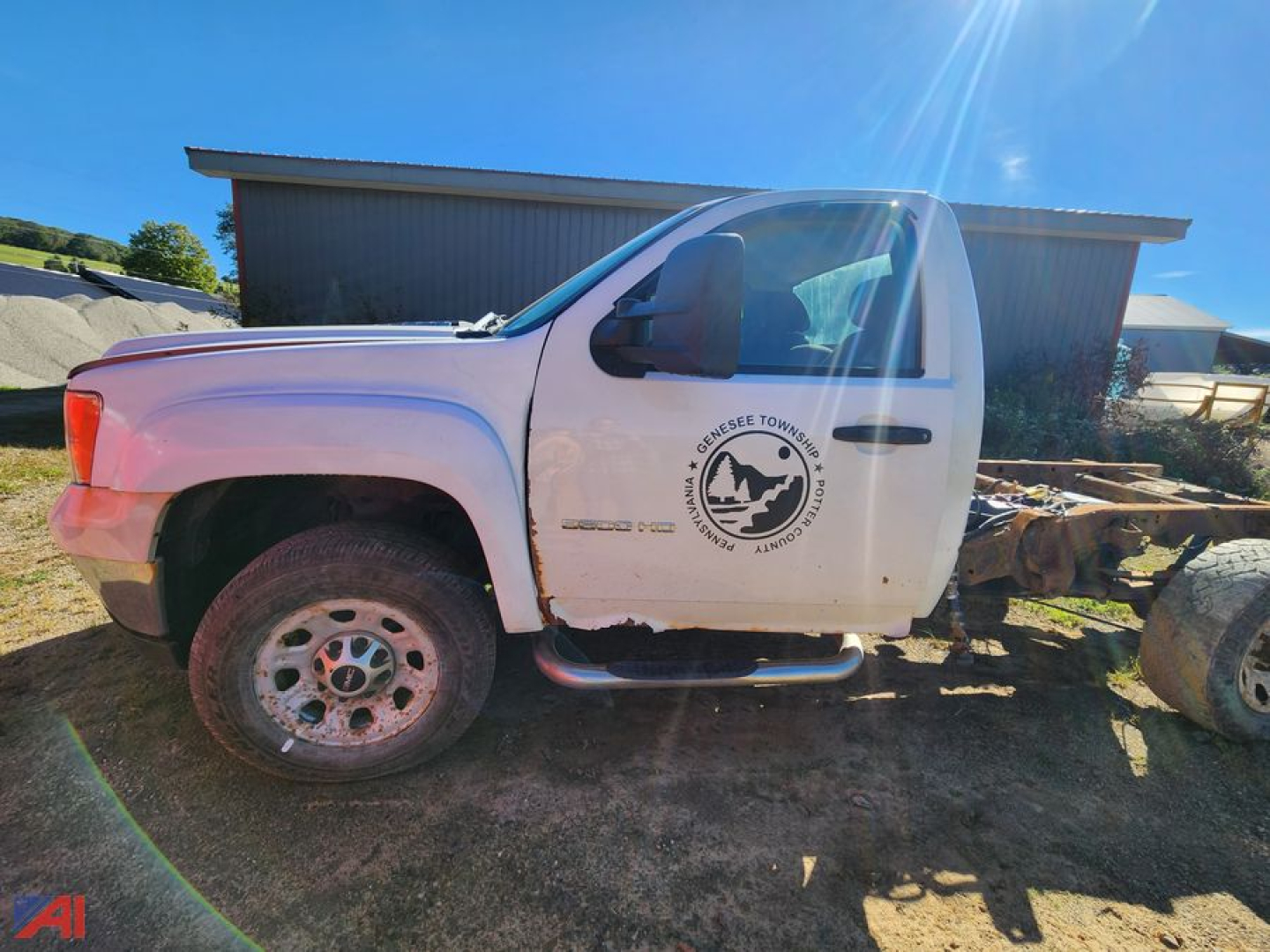 GMC Sierra 3500HD cab and chassis side view showing single cab, white paint, front fender badge, and dual rear axle area.