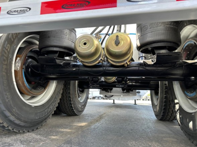 Bottom view of a 2026 Dura Haul air ride bottom dump trailer showing tandem axles, suspension, and underside components.
