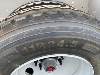 Truck trailer tire and wheel showing 11R24.5 tire size on a Dura Haul air ride bottom dump trailer.