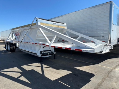 Trailer: white Dura Haul air ride bottom dump trailer showing VIN sticker, stock number NE10330, and side reflectors.