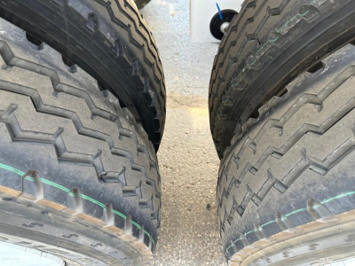 Dual rear truck tires on a trailer showing tread pattern and a glimpse of the underframe; no readable labels visible.