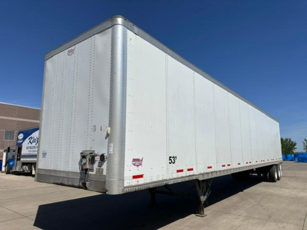 Trailer side and rear showing a 53' box aluminum cargo van with rear dual wheels in a dealership lot.