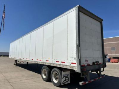 Trailer side and rear view showing a 2016 Wabash box trailer with tri-axle configuration, white exterior, rear doors, and taillights along the undercarriage.