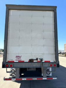 Back of a 2016 Wabash van trailer showing rear doors and bumper with license plate mounts and taillights.