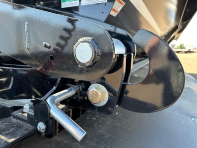 Trailer hitch and coupling mechanism showing metal pin and latch around a mounting plate on a jet 40' air ride side dump trailer.