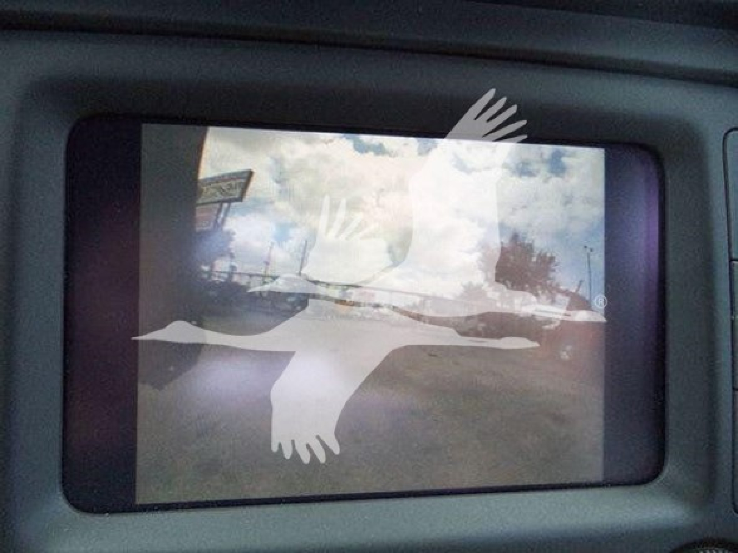 Monitor in a Ram 4500 showing a screen with a white flying bird graphic and a reflection of the outdoors.