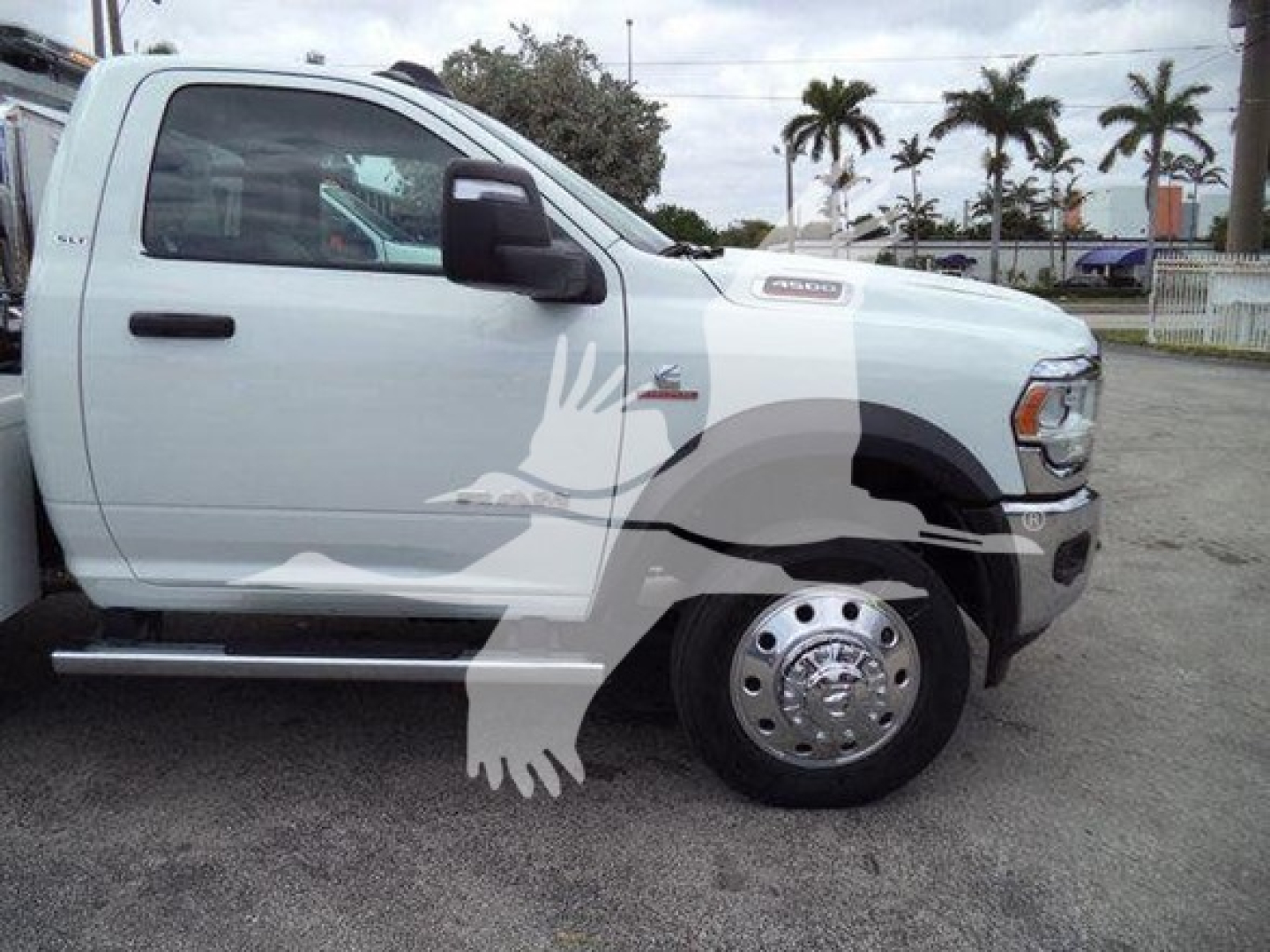 Ram 4500 pickup side view with white paint and custom graphic; visible front wheel, dual rear wheels, side mirror, and hood badge.