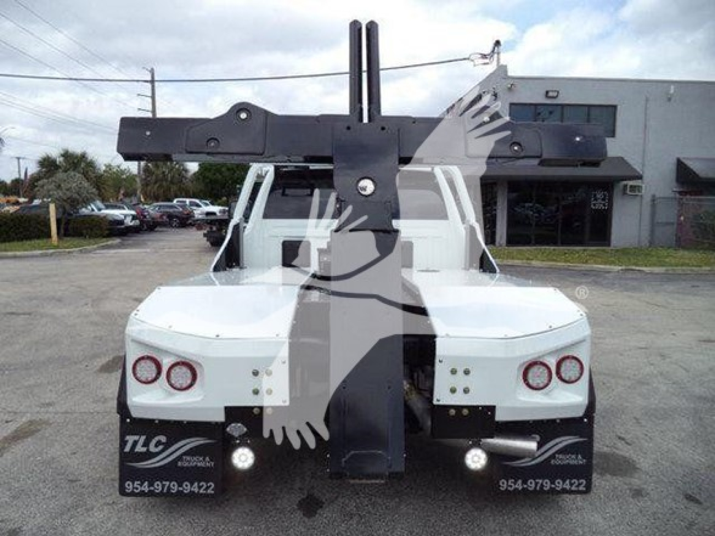 Ram 4500 truck back view with large crane/winch apparatus mounted on bed and hydraulic arms visible.