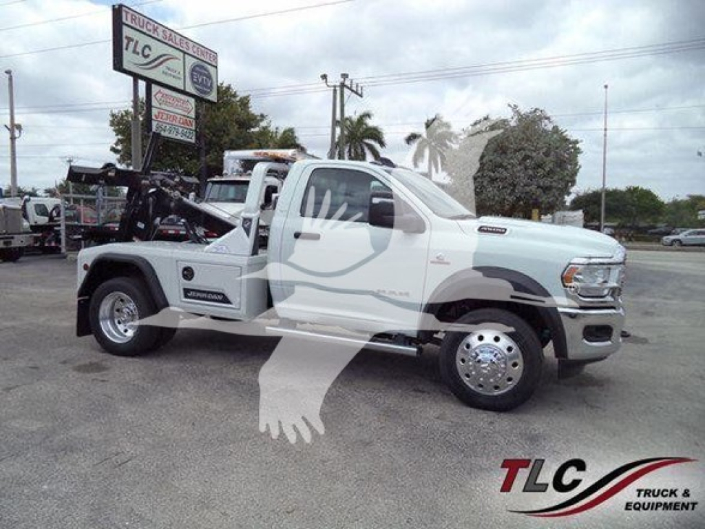 Ram 4500 SLT truck in white, side view, winch setup in bed, branding visible on doors and wheel covers, dealership lot background.