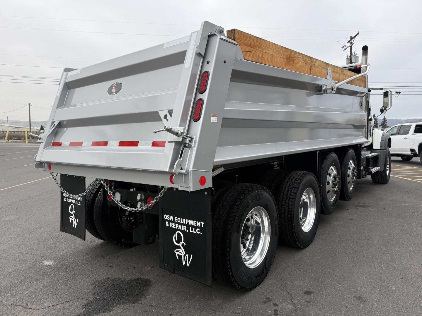 Mack GR104F dump truck rear/right side view showing alloy wheels and gray dump bed.