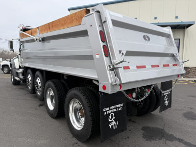 Dump truck bed on a 2025 Mack GR104F showing side panels, rear tailgate, and triple axles with mud flaps.