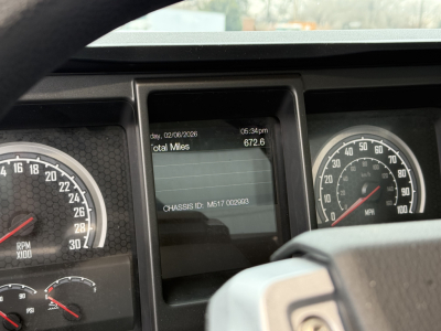 Dashboard display showing total miles 672.6 and chassis ID M517 002993 on Mack GR104F dump truck cab dash.