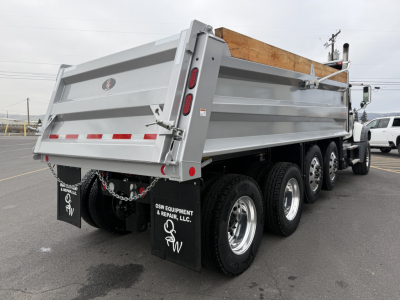 Mack GR104F dump truck rear/right side view showing alloy wheels and gray dump bed.