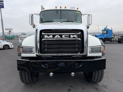 Mack GR104F front view showing bold grille with large 'MACK' lettering, dual headlights, heavy front bumper, and industrial truck in a dealership lot.