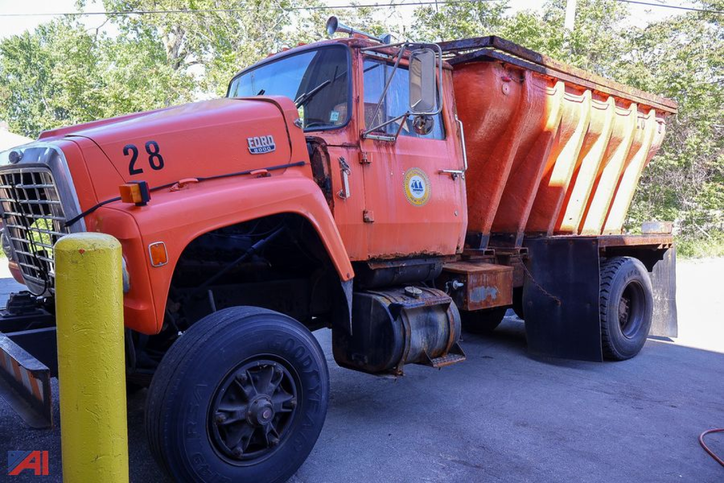 1985 Ford L8000 V-Box Spreader Truck showing orange cab and hopper with the number 28 on door