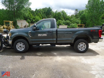 Ford F-250 STX pickup truck with V-plow side view showing crew cab and long bed, green color, off-road tires.