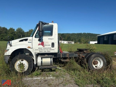 Truck cab side view showing International DuraStar 4400 tractor with white cab, missing rear chassis, and grass surroundings.
